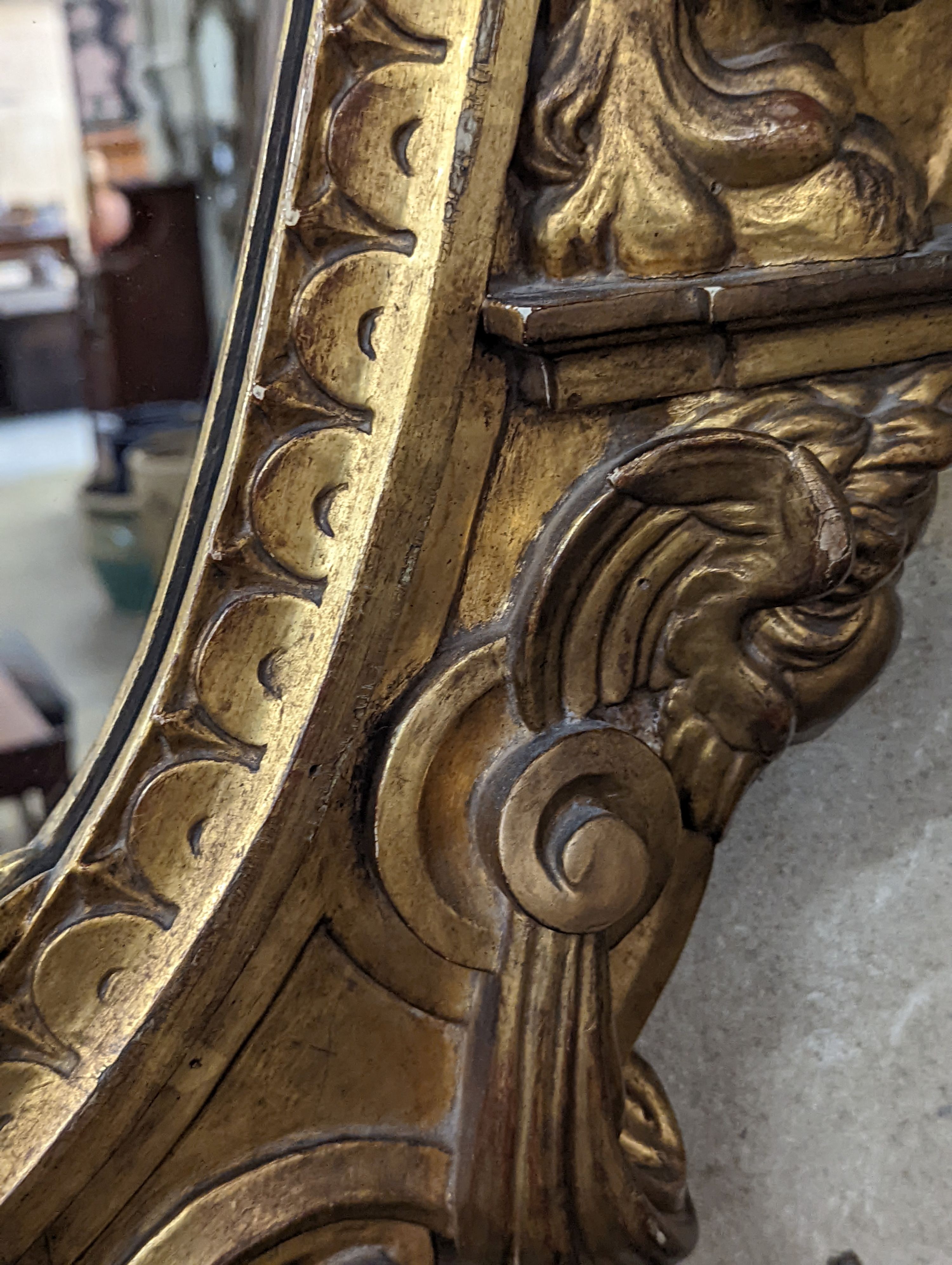 A Victorian carved giltwood oval wall mirror decorated with cherubs and C scrolls., width 74cm, height 110cm